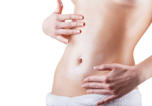 Woman apply body cream on abdomen isolated on white background